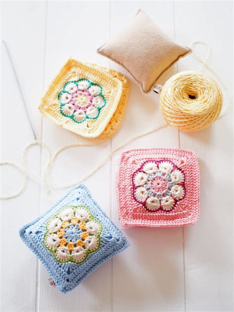 Three Crocheted Squares Are Sitting Next To Each Other On A White