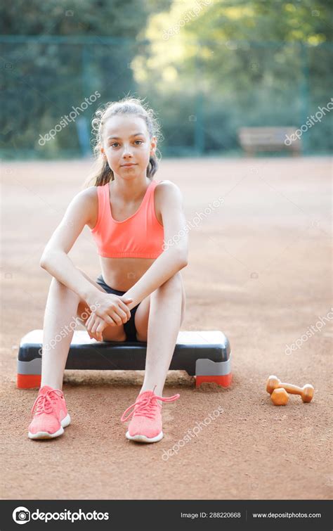 A Cute Pretty Teenage Girl Sits On A Step Platform And Relaxes After Her Workout On Outdoor