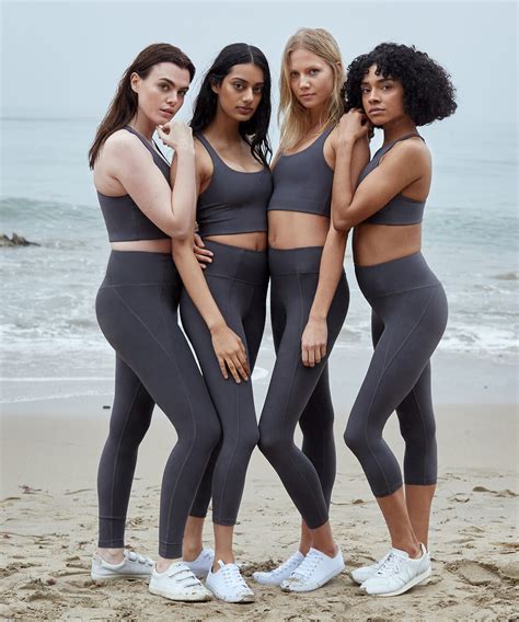 three women standing on the beach in grey sports bra tops and matching leggings