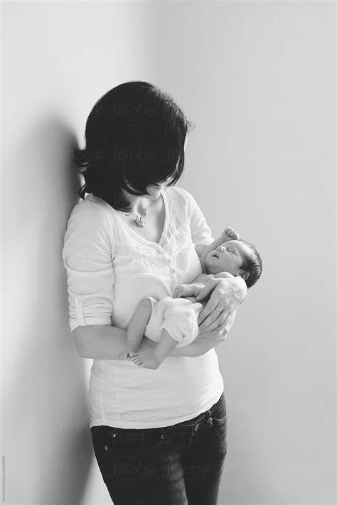 Mother Holding Her Newborn Baby In Her Arms By Stocksy Contributor