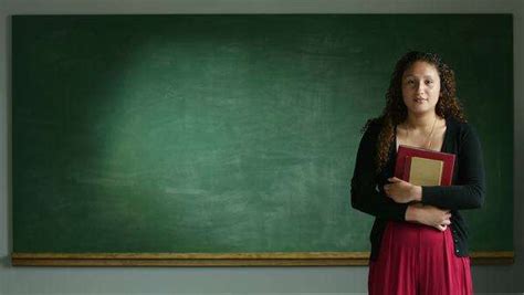 A Student Or Teacher Standing In Front Of An Empty Chalkboard Stock