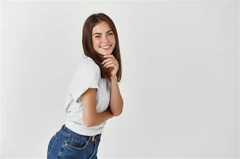 Premium Photo Portrait Of Young Brunette Woman Posing Over White Wall Smiling And Looking