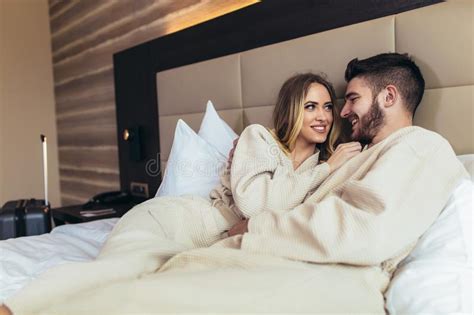 Loving Couple In Bathrobes Relaxing On Bed At Hotel Stock Image Image