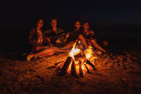 Young Friends Have Picnic With Bonfire On The Beach Stock Photo Image