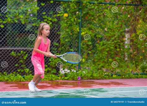 Маленькая девочка играя теннис на суде Стоковое Изображение изображение насчитывающей немного