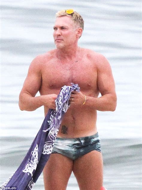 Sam Champion 52 Flaunts His Buff Body On Brazilian Beach Alongside