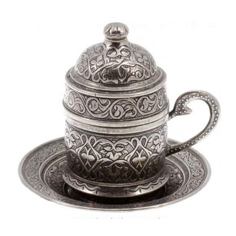 An Ornate Silver Tea Pot And Saucer On A Plate With The Lid Open To
