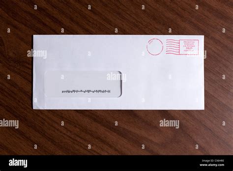 A Window Envelope With No Address But A Barcode And Red Ink Postage