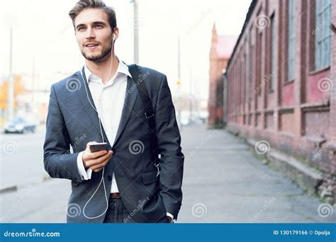 Happy Attractive Young Businessman Walking And Using Mobile Phone