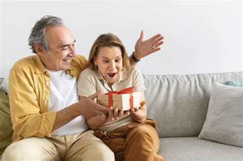 Loving Senior Husband Making Surprise Giving T To Amazed Wife Happy Aged Woman Get