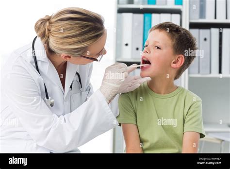 Female Doctor Checking Mouth Of Boy In Clinic Stock Photo Alamy
