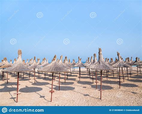 Summer Landscape With Straw Umbrellas On The Beach In Mangalia Or Mamaia Beach At The Black Sea