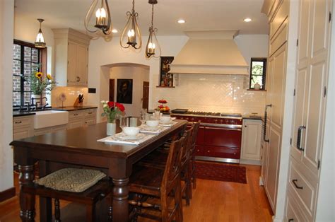 Where an '80s kitchen with laminate counters once stood, a new custom kitchen with mahogany cabinets, granite and soapstone backsplash now comfortable fits in this traditional home. Tudor home remodel