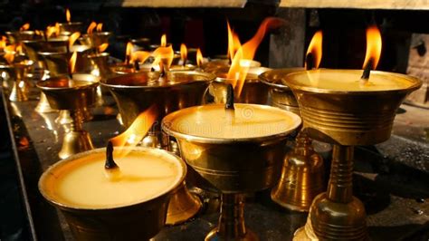 Burning Candles In Temple View Of Golden Shiny Bowls With Burning