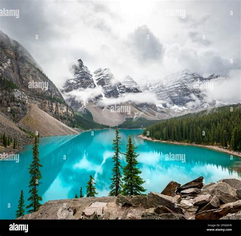 Cloudy Mountain Peaks Reflection In Turquoise Glacial Lake Moraine