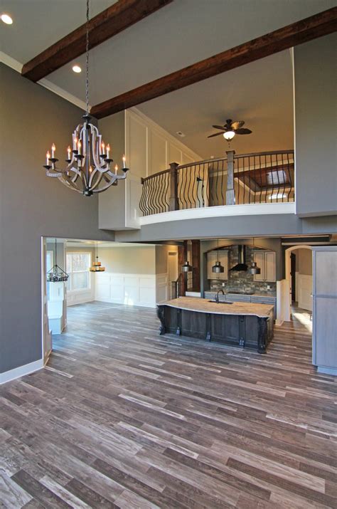 A Large Open Floor Plan With Chandelier And Kitchen Area In The Back Ground