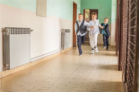 Schoolchildren Running Down The Hallway Stocksy United