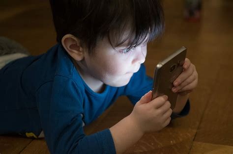 Free Download Boy Staring Samsung Smartphone Leaning Floor