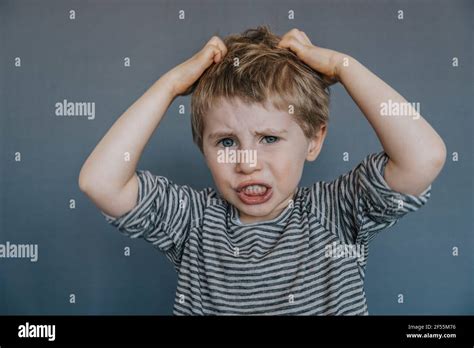Frustrated Boy Scratching Head Against Gray Background Stock Photo Alamy