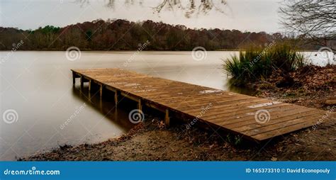 Empty Wooden Dock Leading Into A Smooth Lake Stock Photo Image Of