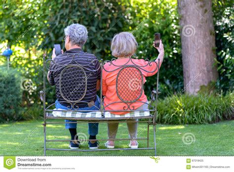 Senior Couple Sitting On Bench With Smartphones Stock Image Image Of Sitting Pensioners 97019425