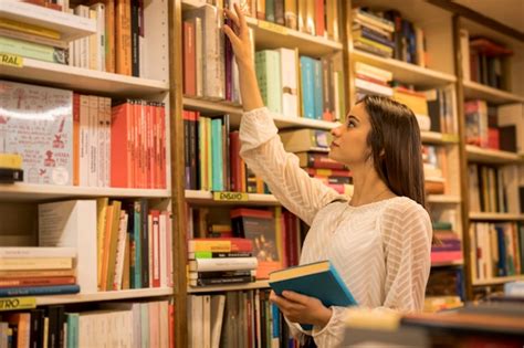 Jeune Femme Choisissant Un Livre Dans La Bibliothèque Photo Premium
