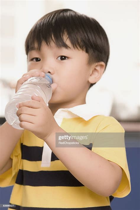 Portrait Of A Boy Drinking Water From A Bottle High Res Stock Photo
