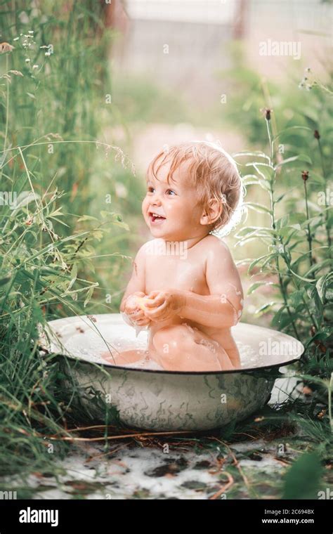 Cute Funny Little Boy Bathing In Galvanized Tub Outdoor In Green Garden