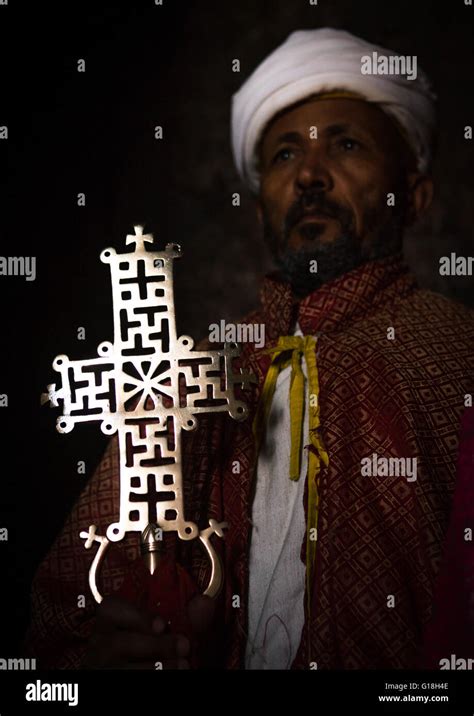Ethiopian Orthodox Priest Holding A Cross Inside A Rock Church Amhara