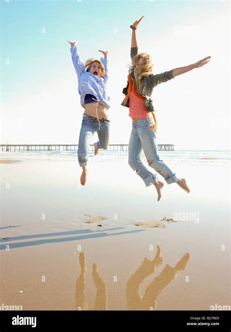 Two Women Jumping On Beach Stock Photo Alamy
