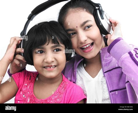 Portrait Of Two Asian Sisters Listening To Music With One Headphone