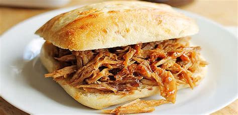 A Pulled Pork Sandwich On A White Plate