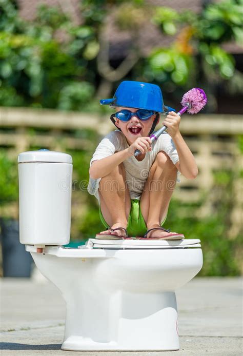 In dem toilettenset ist ein sitz mit deckel und ein. Absurdes Bild: Netter Junge In Den Schutzbrillen, Die Auf ...