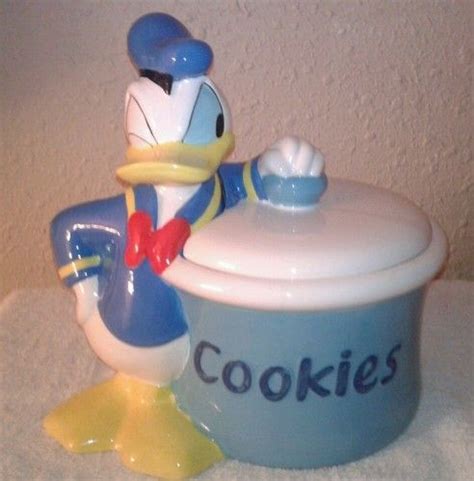 A Toy Donald Duck Is Next To A Cookie Pot With The Word Cookies On It