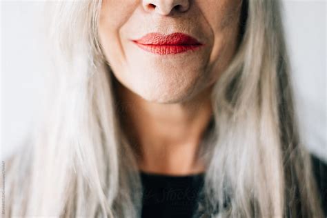 Closeup Portrait Of A Senior Woman With Grey Long Hair And Red Lips