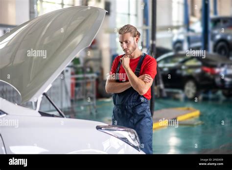 Pensive Repairman Standing Near Car With Open Hood Stock Photo Alamy