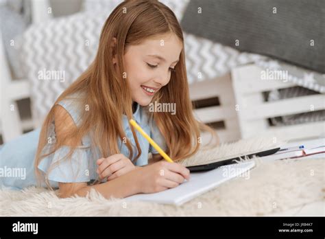 Adorable Kid Writing In Notebook While Studying At Home Stock Photo Alamy