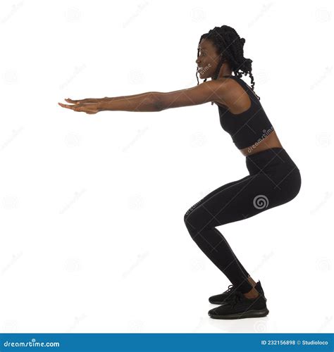 Woman In Black Sports Clothes Is Doing A Squat Full Length Side View