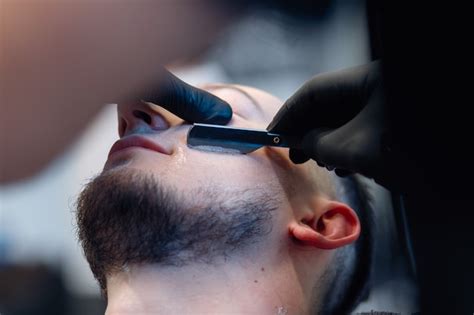 Premium Photo Professional Barber Shaves Customer Beard With Straight