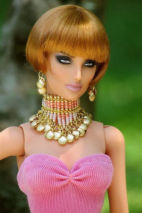 a barbie doll wearing a pink dress with gold jewelry on it s neck and head