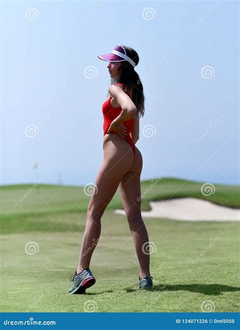 Woman Standing In Red Swimsuit Bikini Near Golf Course Field From