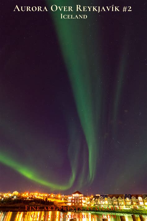 The Aurora Borealis Sweeps In A Curving Dance Above The Lights Of