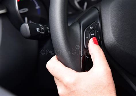 Female Finger On Volume Control Button On Car Steering Wheel Stock