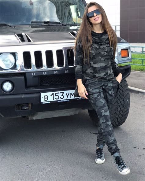 A Woman Standing Next To A Parked Jeep
