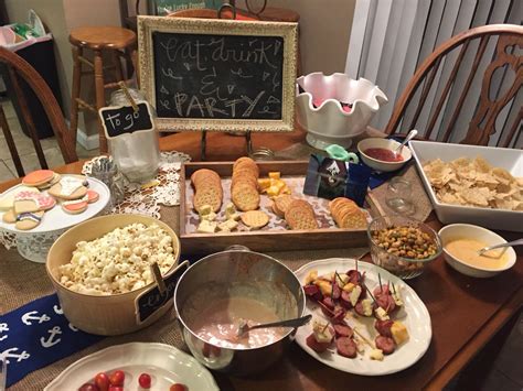 A Wooden Table Topped With Plates And Bowls Filled With Food Next To A Chalkboard