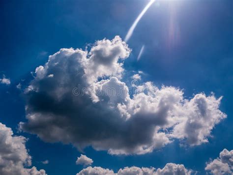 Beautiful Fluffy Cloud In The Blue Sky With Rounded Sunbeam Stock
