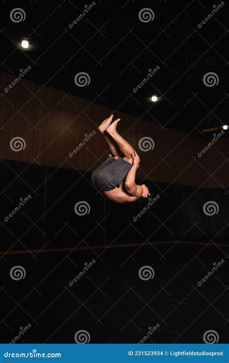 Barefoot And Shirtless Gymnast Doing Somersault Stock Photo Image Of Fitness Indoors