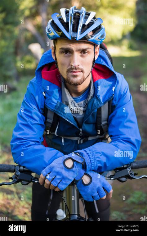 Portrait Of Male Mountain Biker With Bicycle In The Forest Stock Photo