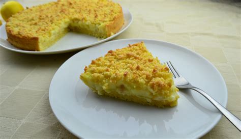 Un dessert davvero delizioso la crostata al limone. Crostata sbriciolata con crema pasticcera e pinoli.