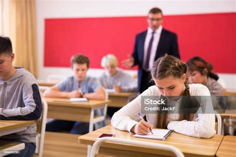 Teen Girl Sitting At Desk In Classroom Stock Photo Download Image Now